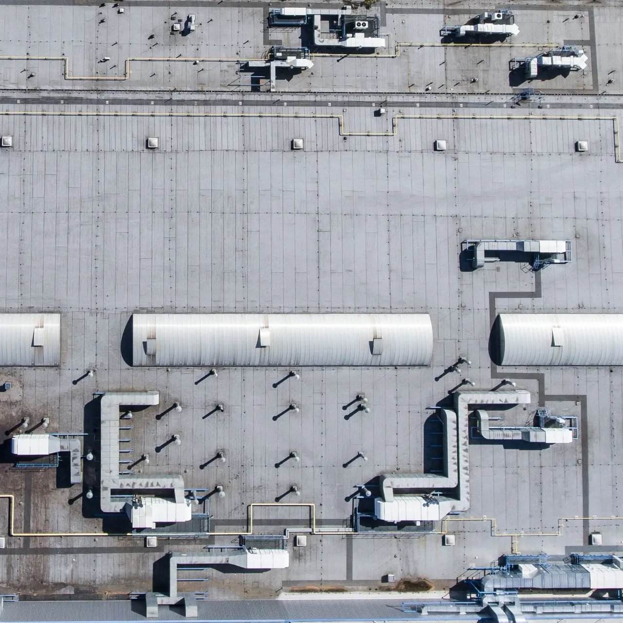 Commercial flat roof from above with ducts and rooftop equipment